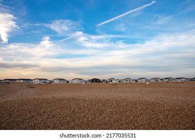 Mobile holiday homes park in Selsey at shingle beach in sunset, golden hour light