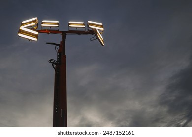 Mobile LED (light-emitting diode) light tower, against an ominous semi-dark sky. Moved, placed in area at mine where illumination is required