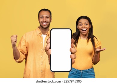 Mobile Mockup. Excited Black Couple Showing Huge Blank Smartphone With White Screen At Camera, Happy Young African American Man And Woman Demonstrating Empty Cellphone With Copy Space, Collage - Shutterstock ID 2257945305