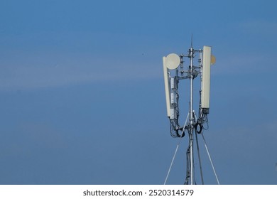 Mobile network antenna or Wi-Fi internet. Cellular network equipment on top of a building with a blue sky background - Powered by Shutterstock