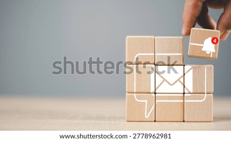 Mobile notification alert concept with message icon and update badge on wooden blocks. Digital communication and user engagement for smartphone interface and modern technology.