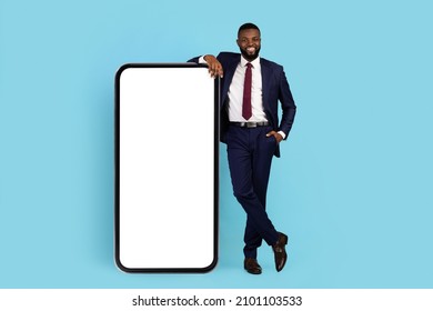 Mobile Offer. Handsome Black Businessman Leaning At Big Blank Mobile Phone, Smiling African American Male Entrepreneur Showing Copy Space For Online Ad Or App Design, Full Length Shot, Mockup - Shutterstock ID 2101103533