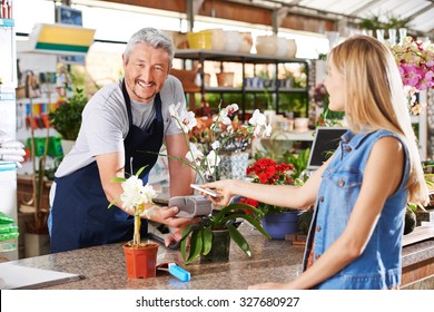 Mobile payment in garden center with salesman and customer - Powered by Shutterstock