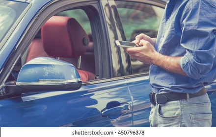 Mobile phone apps for car owners concept. Man using smart phone to check status, control  his new car