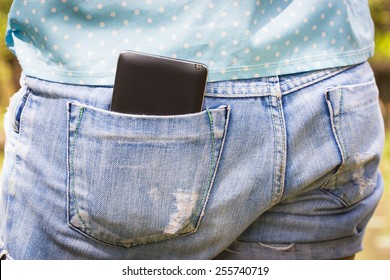 Mobile phone in the back pocket of blue jeans
