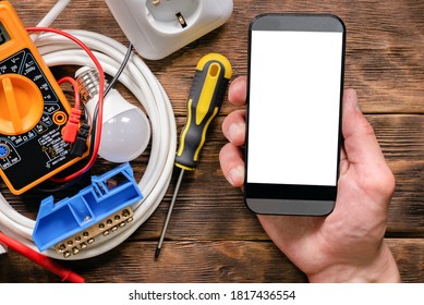 Mobile phone with blank screen in the electrician hands close up.