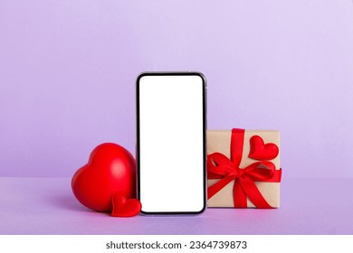 mobile phone with blank screen on colored background with hearts, calendar and gift box, valentine day concept perspertive view flat lay. - Shutterstock ID 2364739873