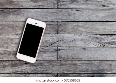 Mobile phone with blank screen on wooden table background with copy space