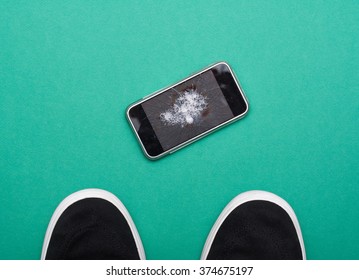 Mobile Phone With Broken Screen On Green Floor