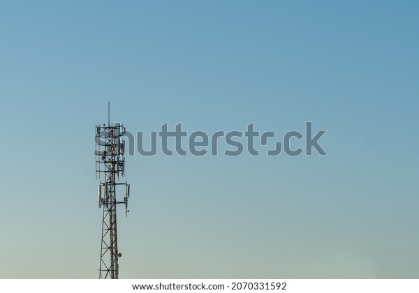 Mobile Phone Call Tower with blue sky background\
illustrating the digital\
divide