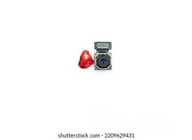 A mobile phone camera next to a pomegranate fruit seed, for size comparison - Shutterstock ID 2209629431