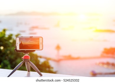 Mobile Phone Camera On A Tripod Capturing The Color Of The City.