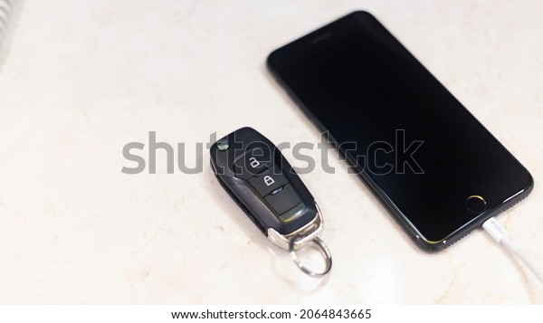 MOBILE PHONE AND CAR KEYS ON NIGHT TABLE WITH\
MARBLE TEXTURE