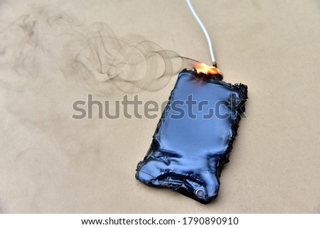 Mobile phone caught fire from the wire with recharging from the electrical network in the socket. Inexpensive chargers put your  cell at risk. Cable overheat and catch fire. Smartphone burn