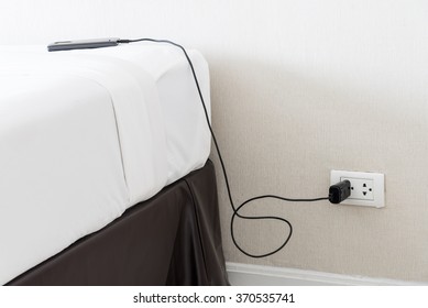 The Mobile Phone Charger With Wall Outlet In The Bedroom.