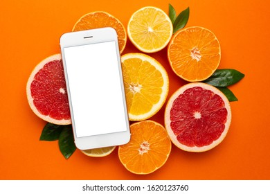 Mobile Phone And Citruses On An Orange Background, Fruit Flatlay, Summer Minimal Compositon With Grapefruit, Lemon, Mandarin And Orange