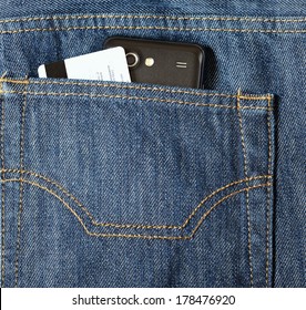 Mobile phone and credit card in a jeans pocket