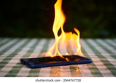 Mobile phone explodes and burns. Cell Phone explosion and fire. Smart Phone Danger from over use or bad manufacturing. Burning up overheating Smart phone concept.
