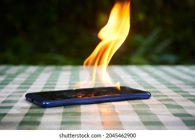 Mobile phone explodes and burns. Cell Phone explosion and fire. Smart Phone Danger from over use or bad manufacturing. Burning up overheating Smart phone concept.
