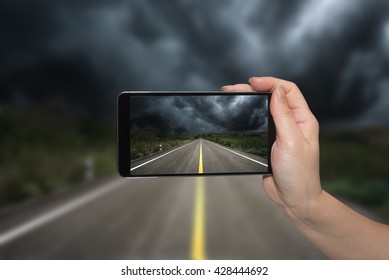 Mobile Phone In Hand And Storm Landscape