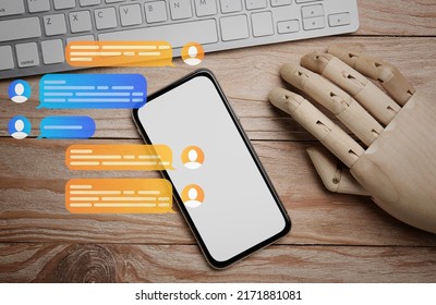 Mobile phone with mannequin hand and computer keyboard on wooden background. Online chatting - Powered by Shutterstock