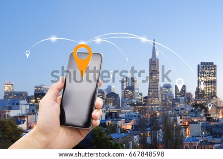 mobile phone with modern buildings in san francisco at twilight