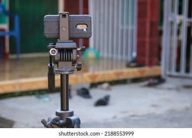a mobile phone mounted on a tripod fluid head, for smoother camera movement.