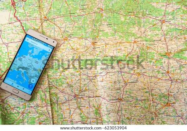 Mobile phone\
navigation program on a paper road\
map