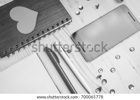 Mobile phone, notebook, pens, pushpin black and white frame
