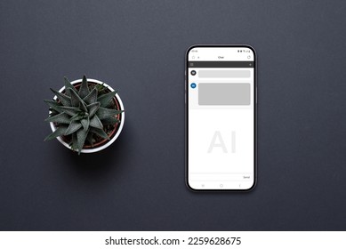 Mobile phone on the desk with a chat AI app. Conceptual design of app to communicate with artificial inteligence. Plant beside, top view, flat lay