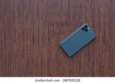 Mobile Phone On Wooden Desktop. Top View