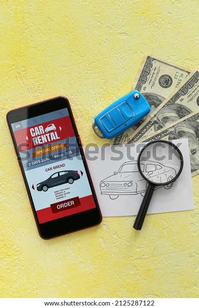 Mobile phone with open car rent app,\
drawn auto, money and magnifier on yellow\
background