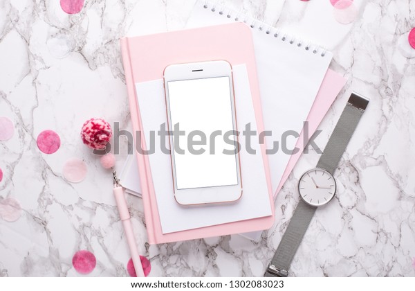 大理石の背景にピンクのデコレーションが付いたピンクのノートパソコンと携帯電話 の写真素材 今すぐ編集