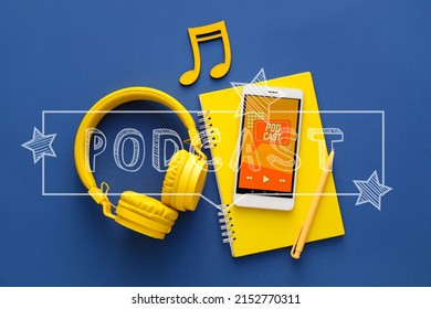 Mobile phone with podcast playlist on screen, notebook and headphones with note symbol on blue background