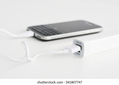 Mobile phone portable battery recharging a smartphone