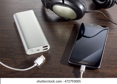 Mobile Phone And Power Bank Battery On Dark Background