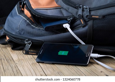 Mobile Phone With Powerbank On Wooden Table Background. 