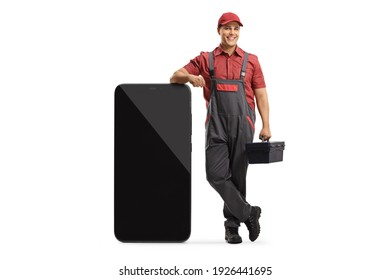 Mobile Phone Repairman Leaning On A Big Smartphone And Holding A Tool Box Isolated On White Background