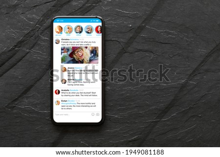 Mobile phone with sample social media microblogging app on the screen
