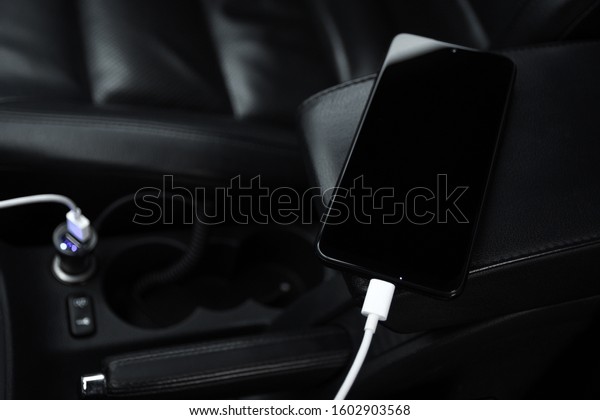 Mobile phone, smartphone charge battery, charging in\
the car plug close up