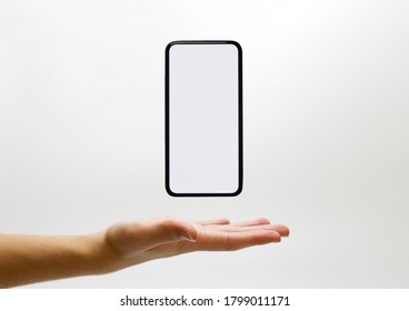 Mobile phone smartphone floating in palm of hand with a blank copy space display screen