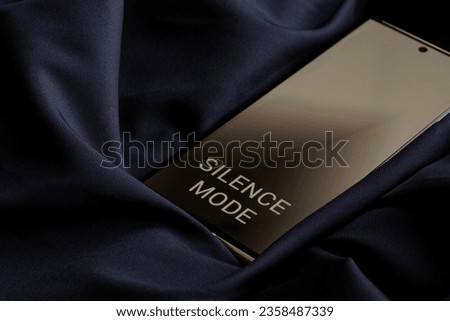 Mobile phone - a smartphone with silence mode enabled in sound-absorbing fabric. Barring incoming calls and messages. Copy space. Black background. Selective focus. Close-up