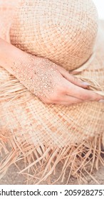 Mobile phone wallpaper, beach sandy hand touch a straw hat warm tone filter