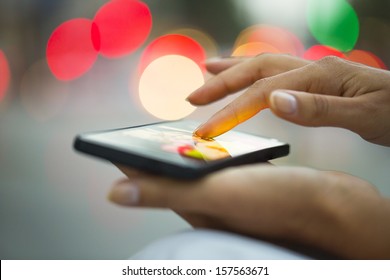 Mobile phone in a woman's hand, night, city ??of Light background, sms, message, e-mail  - Shutterstock ID 157563671