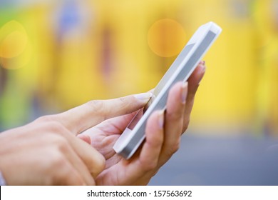 Mobile Phone In A Woman's Hand, Yellow Store Background, Message, Sms, E-mail 