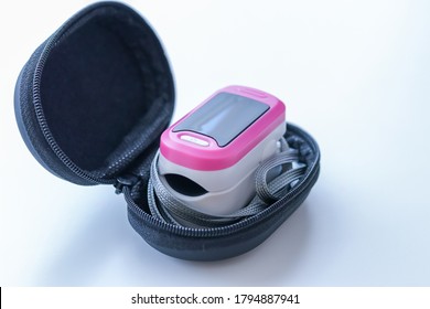 Mobile Pink Pulse Oximeter In A Black Case On A White Background