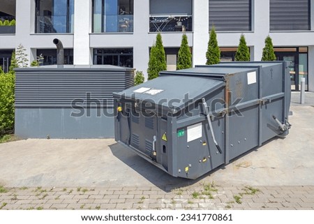 Mobile Press Container Compactor for Reducing Volume of Municipal and Industrial Waste Behind Building