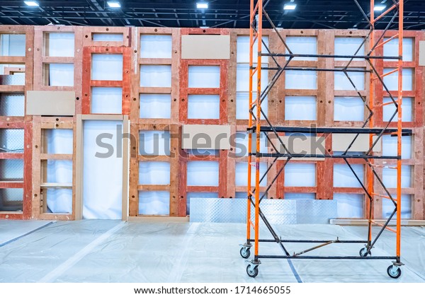 Mobile\
scaffolding on the background of the repaired premises. Scaffolding\
on wheels. Construction equipment. Installation of partitions in\
the room. Installation of wooden\
frames.