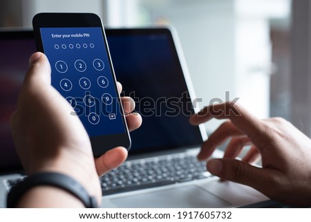 Mobile security concept, Man using a digital generated phone with security pin code on blue screen