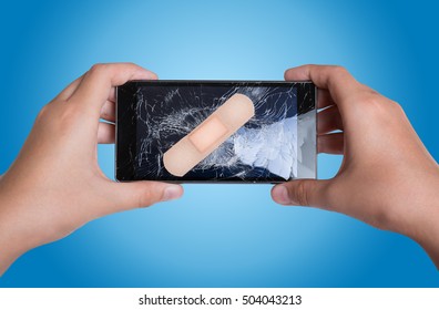Mobile Smart Phone with cracked screen with plaster in hands